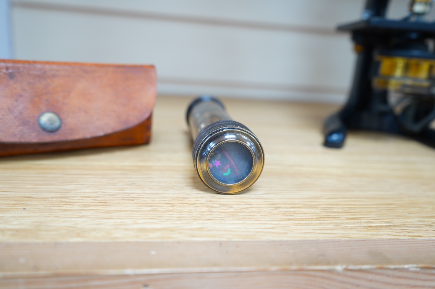 A reproduction 19th century style brass kaleidoscope with panel reading; ‘Gilbert & Sons To Her Majesty’s Royal Navy, 8 Street Black Wall, London 1895’, 13.5cm long, in a leather case, together with a wood cased brass so